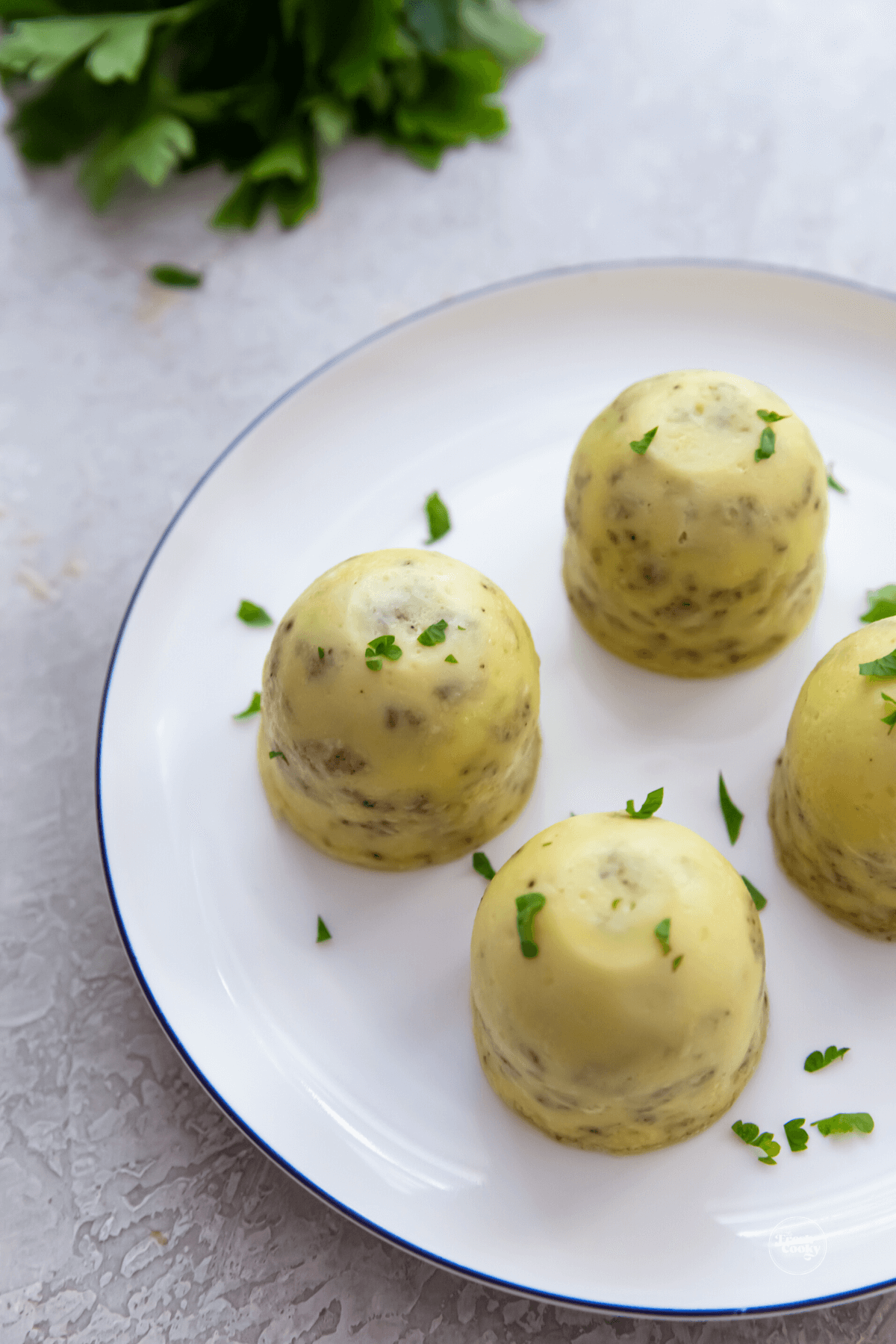 4 perfect Starbucks egg bites with sausage and cheese on plate.