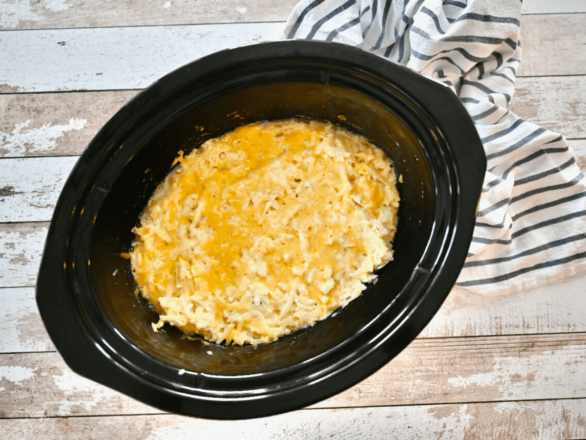 Cheesy Hashbrown Casserole in crockpot, ready to serve this vegetarian dish.