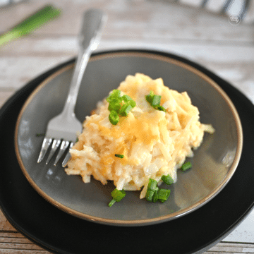 Serving of Crockpot Cracker Barrel Hashbrown Casserole on a gray plate.