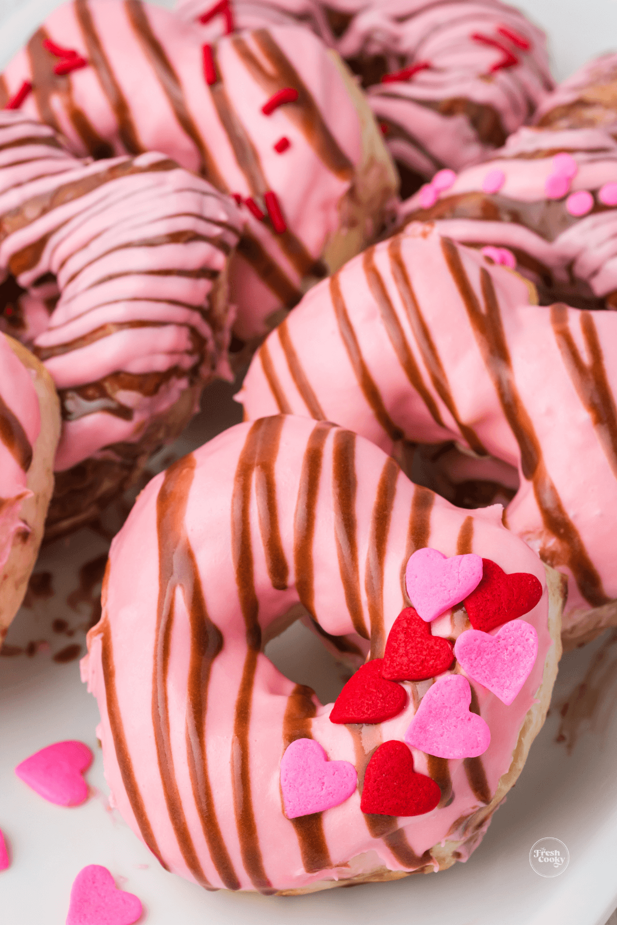 Close up of glazed air fryer heart shaped biscuit donuts.