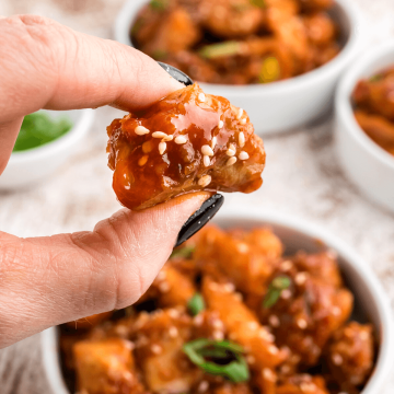 Easy Korean Fried Chicken piece held between fingers.