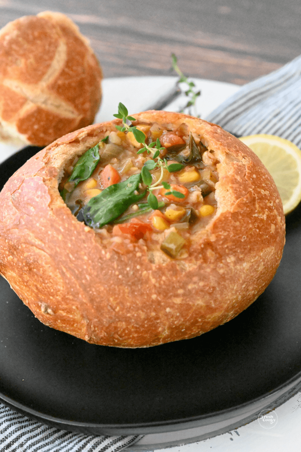 Panera Bread 10 vegetable soup in bread bowl with top in background for eating.