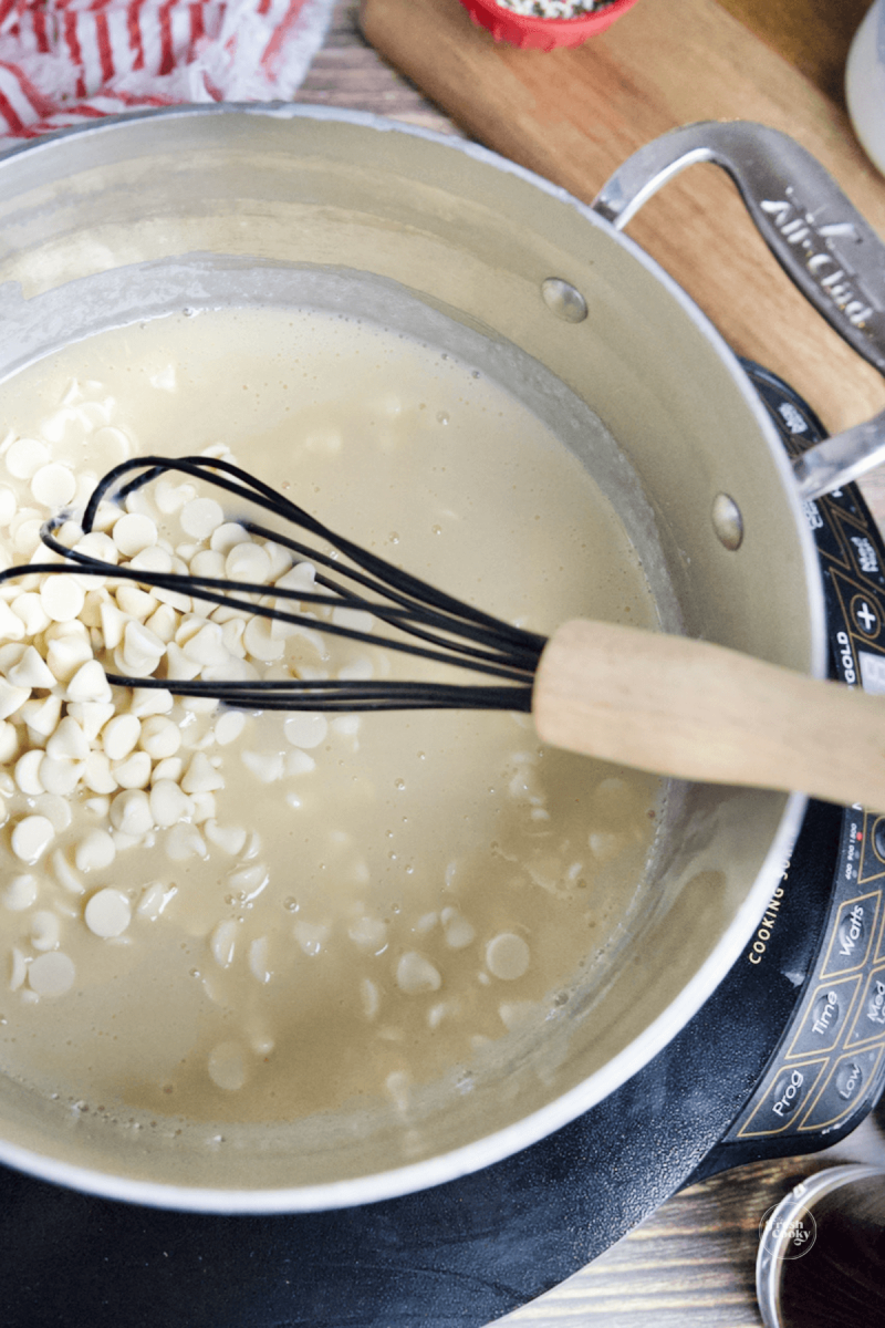 Whisking white chocolate chips until smooth.