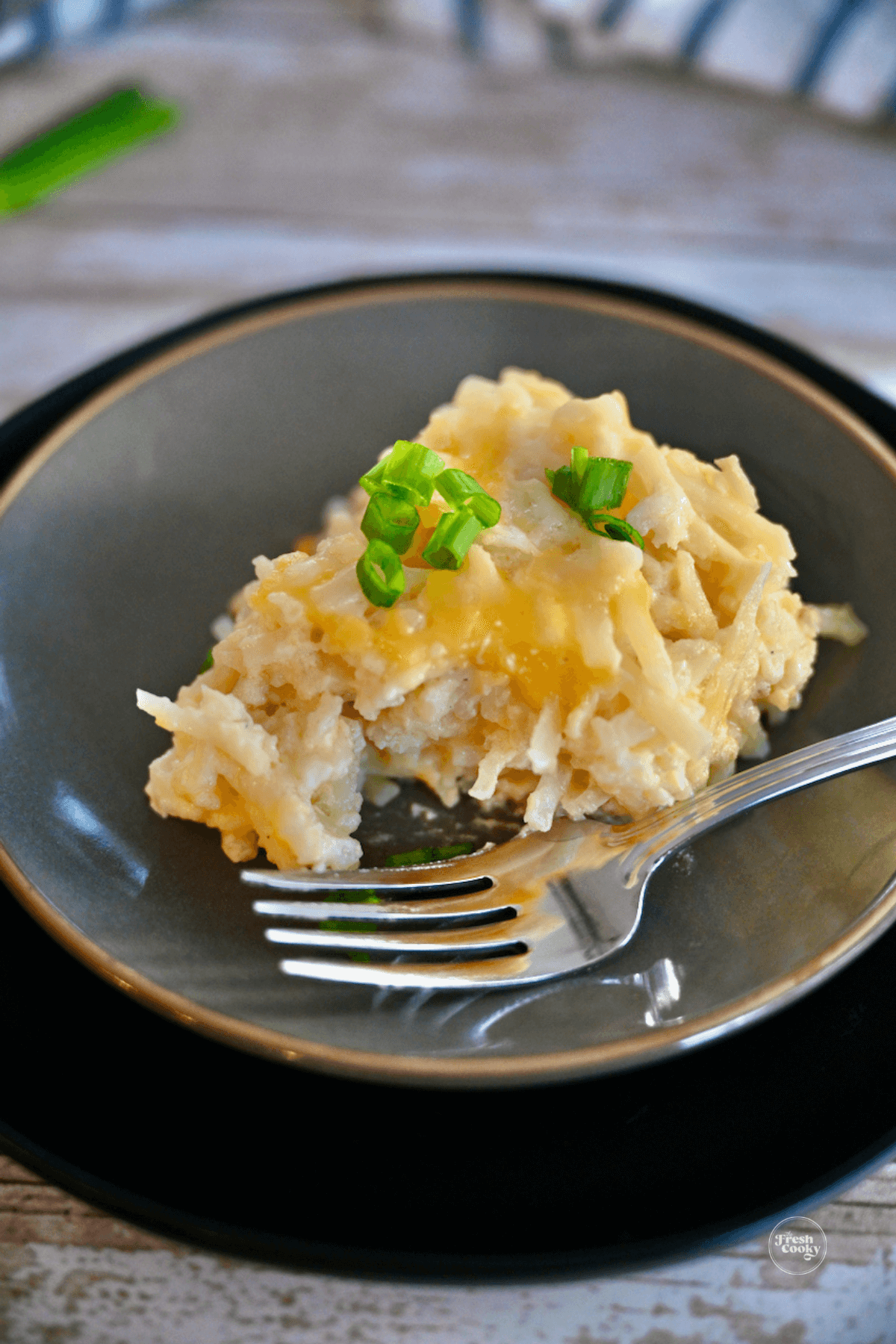 Cracker Barrel Hashbrown Casserole vegetarian on plate with bite taken out and fork nearby.