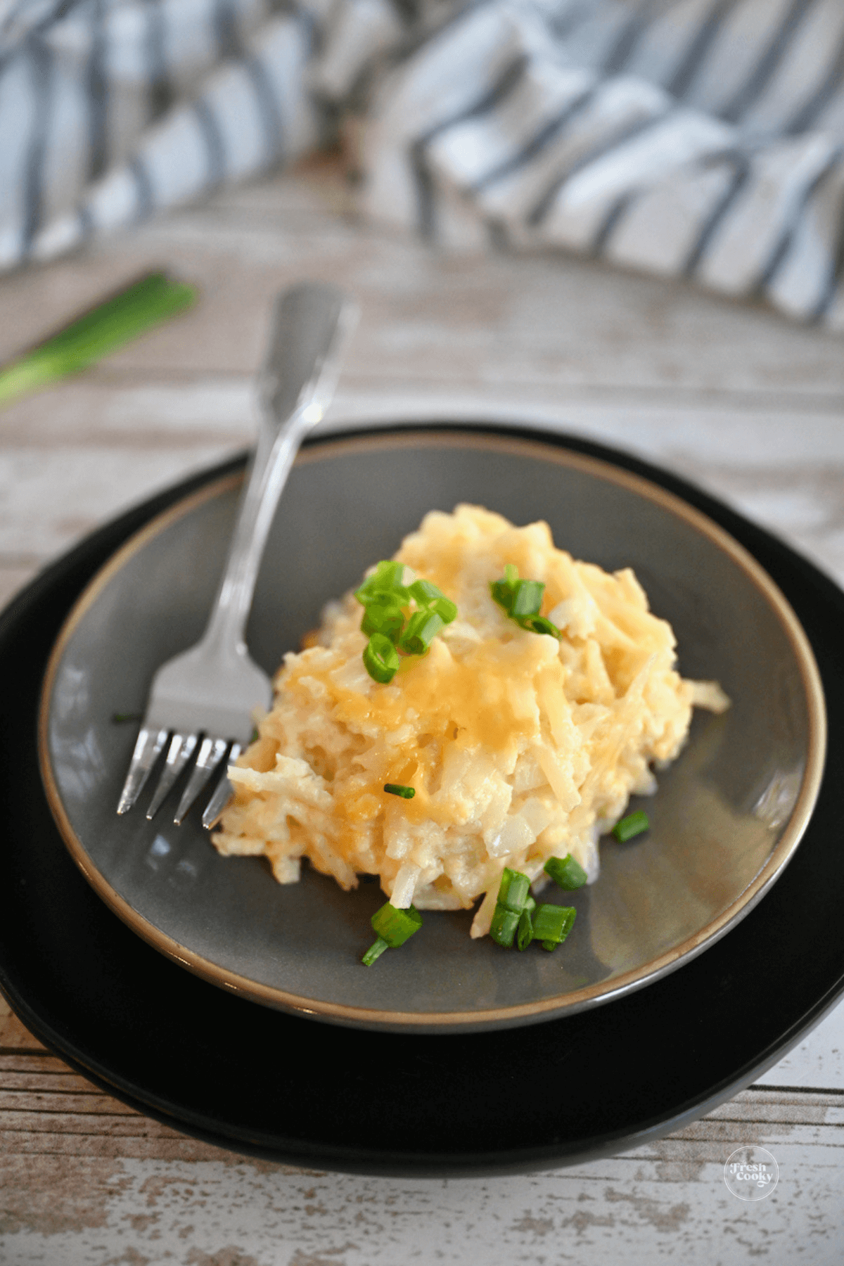 Cracker Barrel Hashbrown Casserole serving on a plate, with a fork.