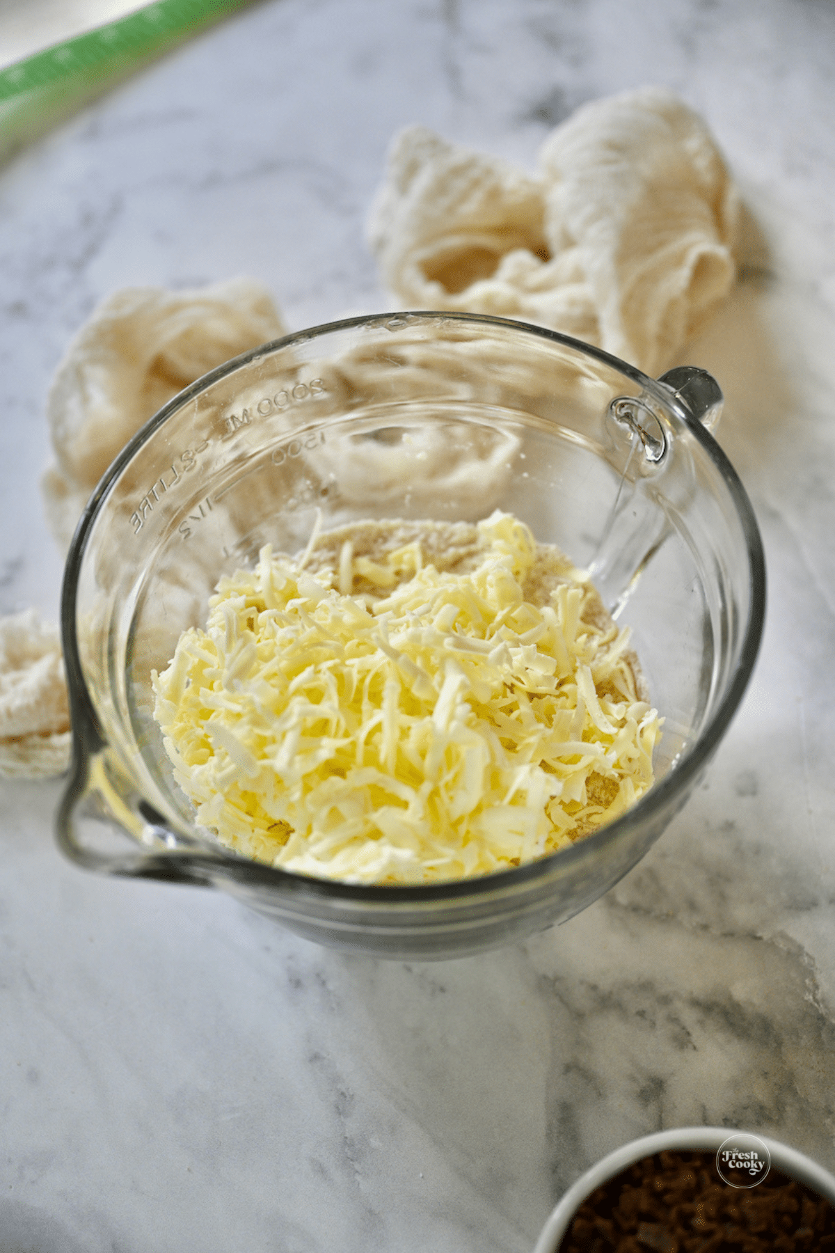 Adding grated butter to cinnamon chip scone dry ingredients.