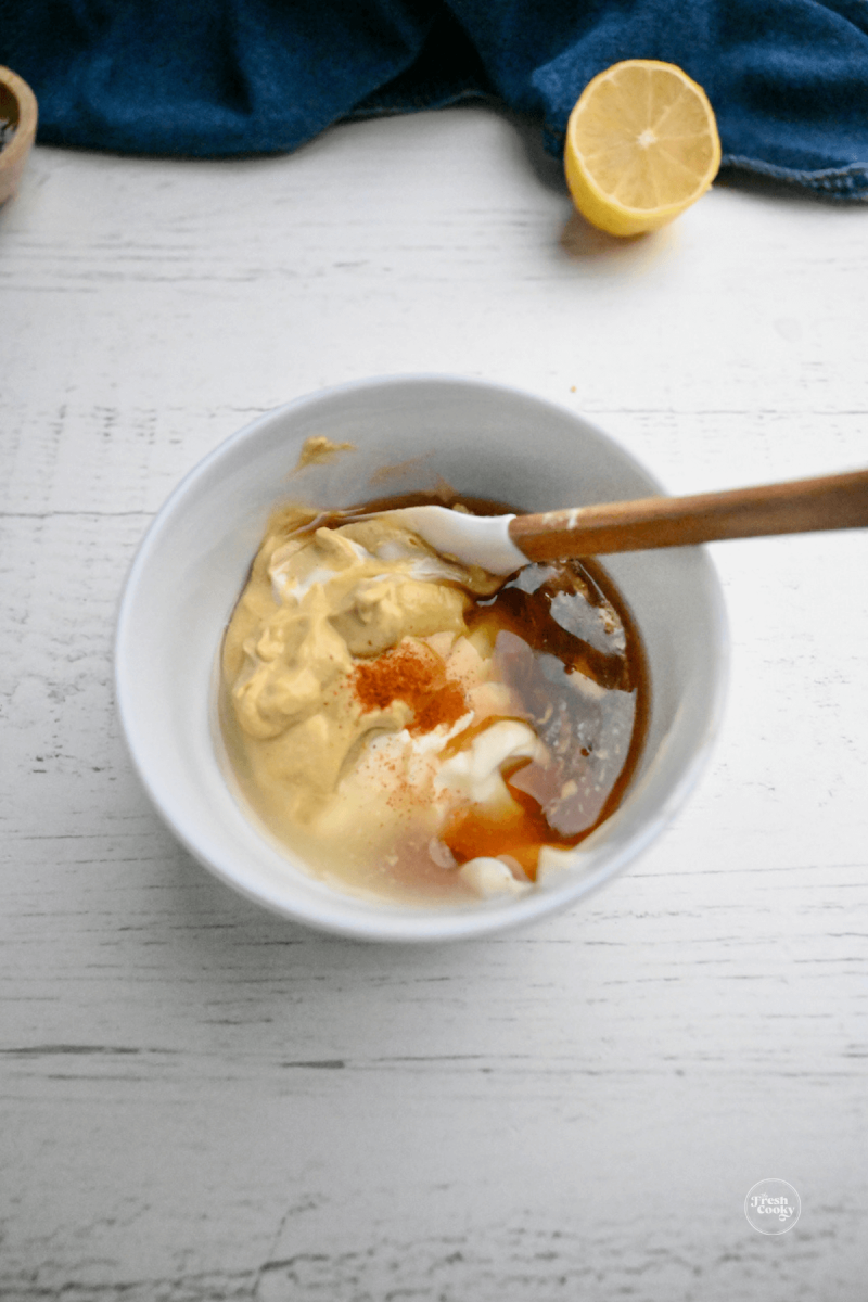 Ingredients in bowl for honey mustard sauce.