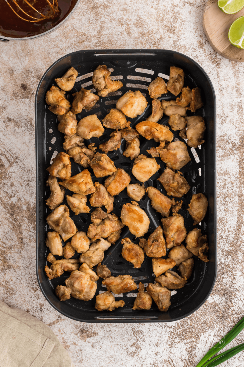 Extra crispy fried chicken in air fryer basket.