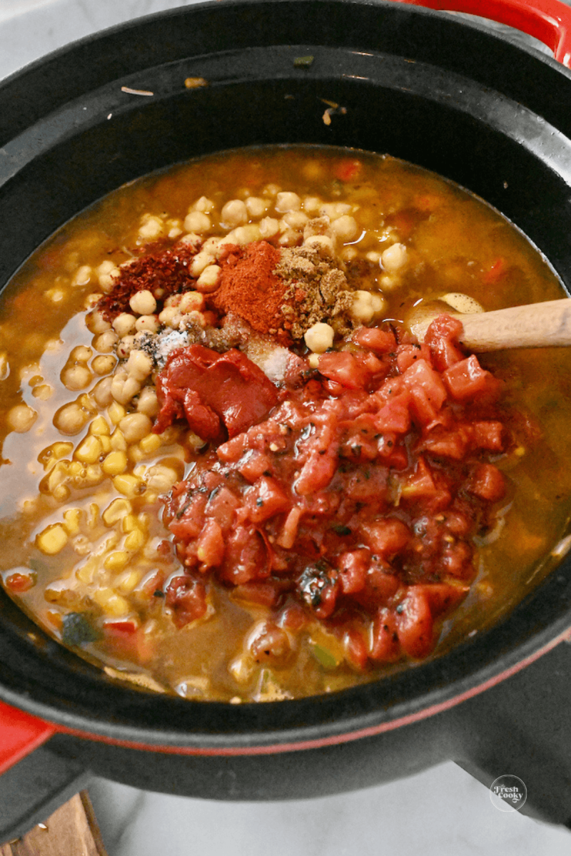 Adding garbanzo beans, corn, tomatoes, tomato paste.