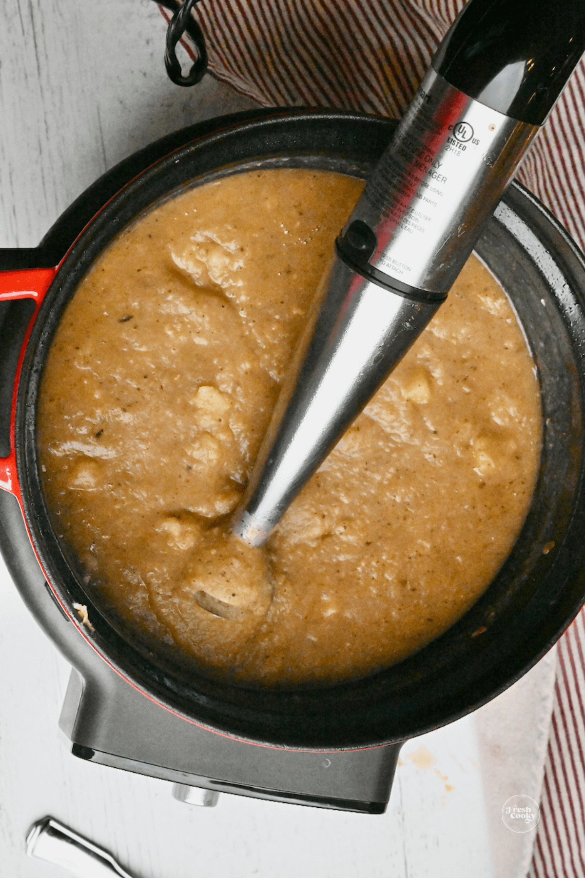 Immersion blender with mostly blended potato soup. 