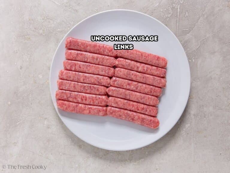 Uncooked sausage links on a plate.