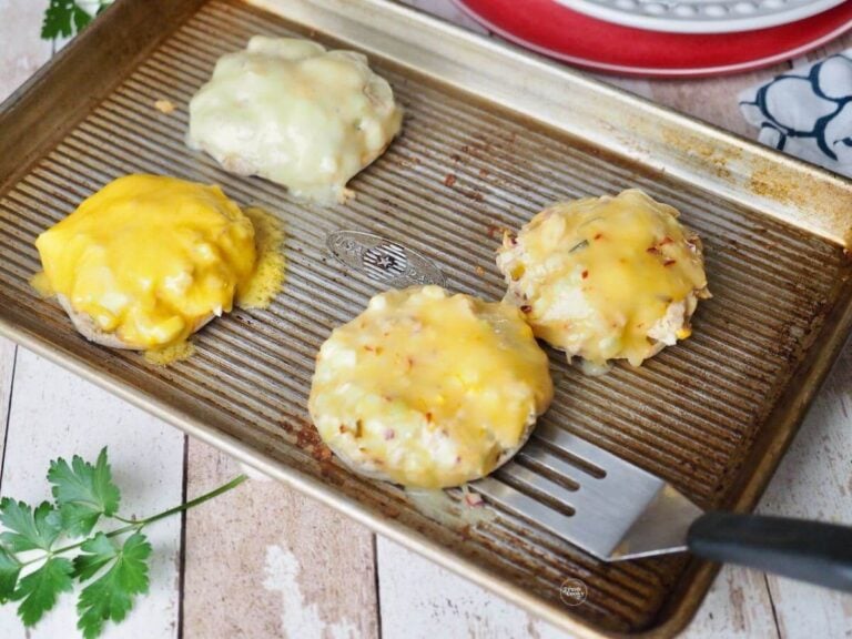 Spatula pulling a couple of tuna melts off of a quarter sheet pan.