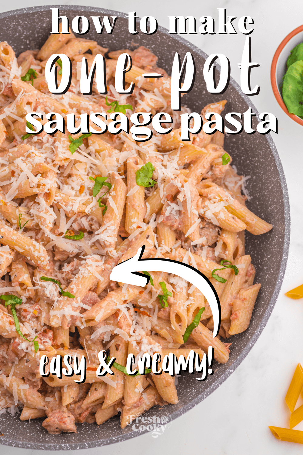 Skillet filled with creamy, one pot pasta with Italian sausage in a creamy, parmesan tomato sauce.