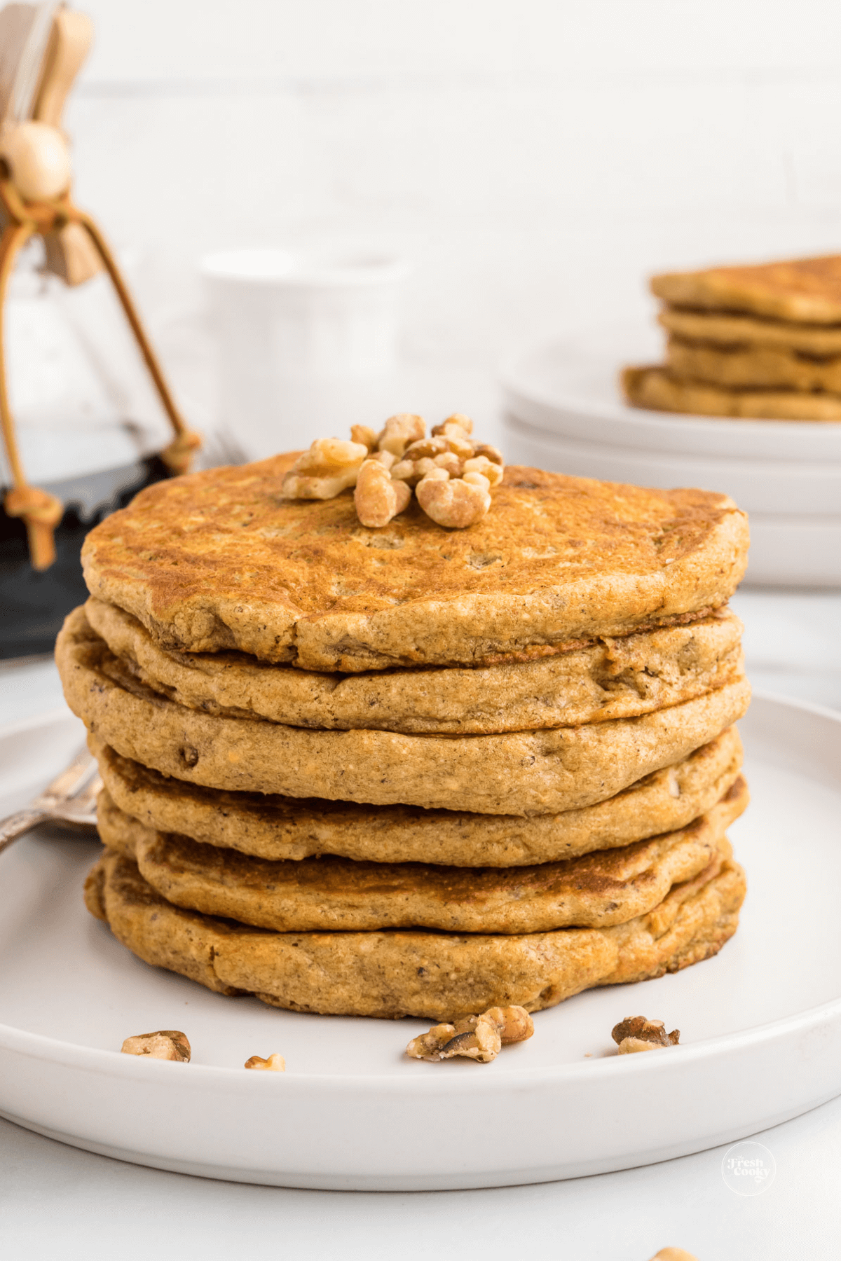 Stack of pancakes sprinkled with some chopped walnuts.