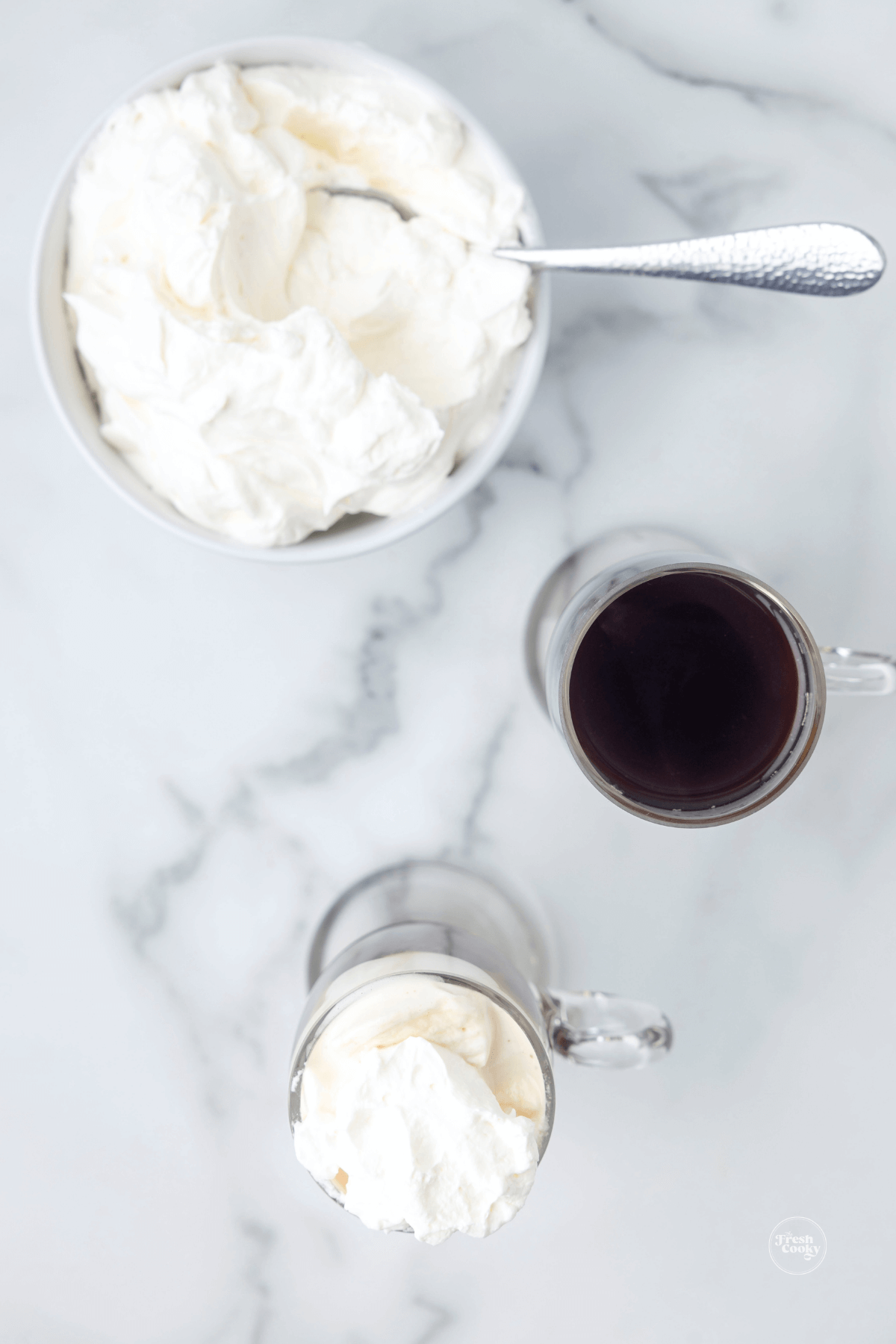 Dollop of whipped cream placed on top of Irish coffee.