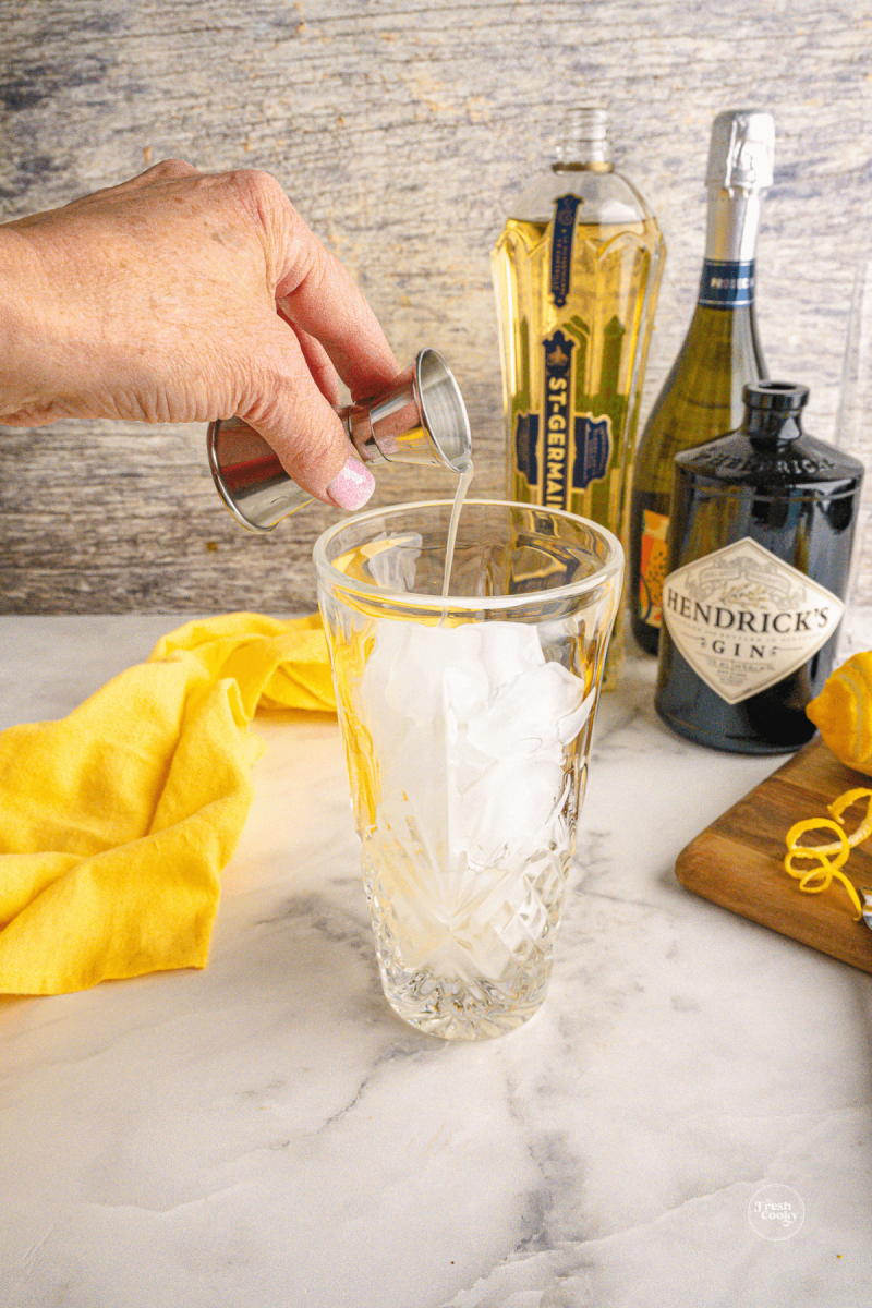 Pour lemon juice into cocktail shaker. 
