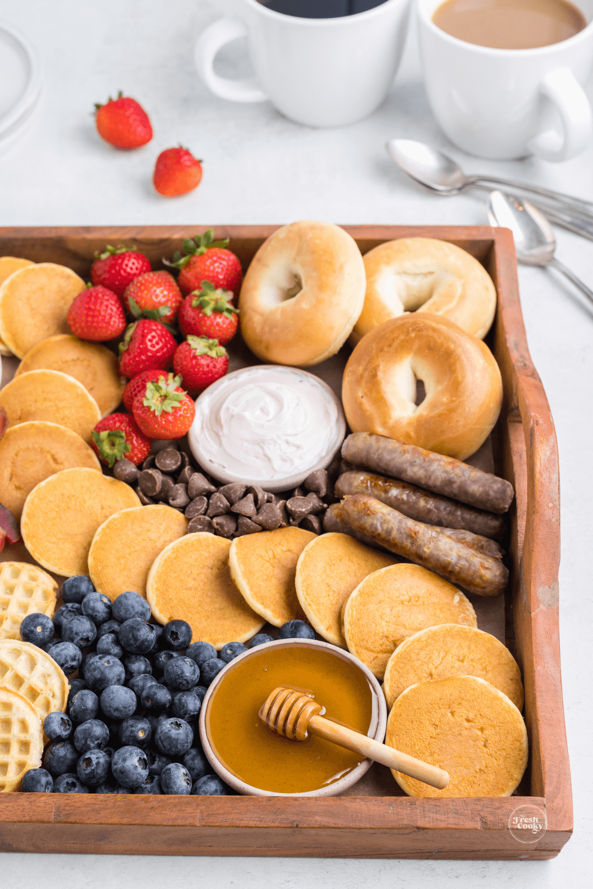 Beautiful pancake breakfast charcuterie board with coffee behind.