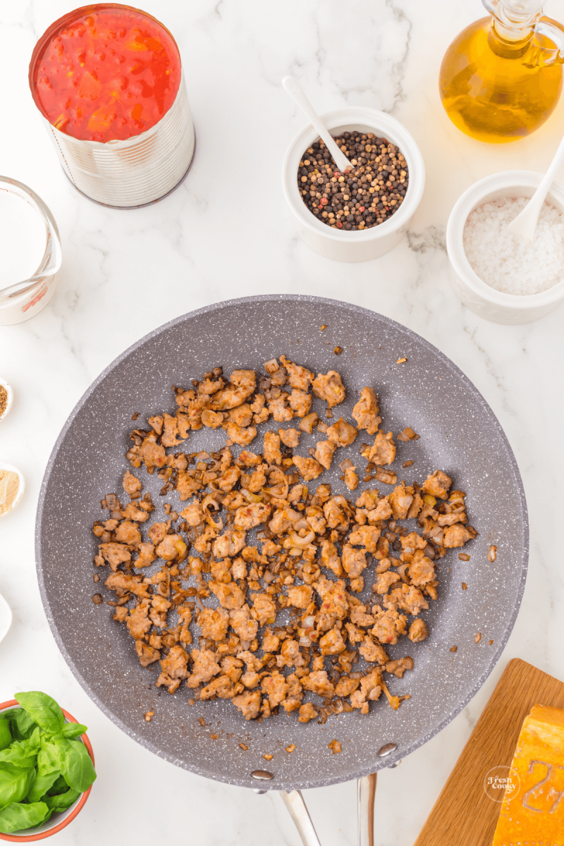 Browning sausage in skillet with shallots.