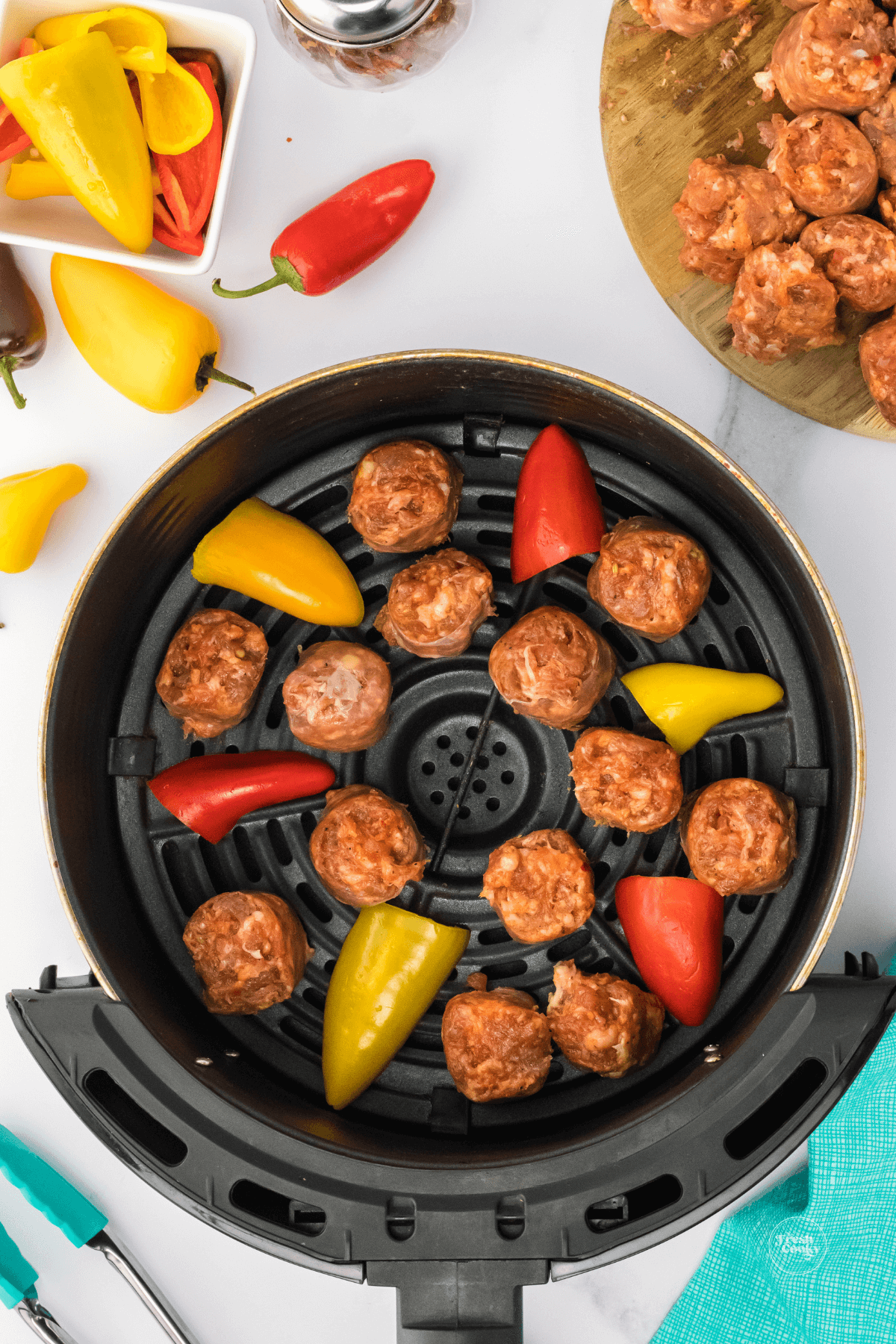 Add sausage bites and peppers in single layer to air fryer.