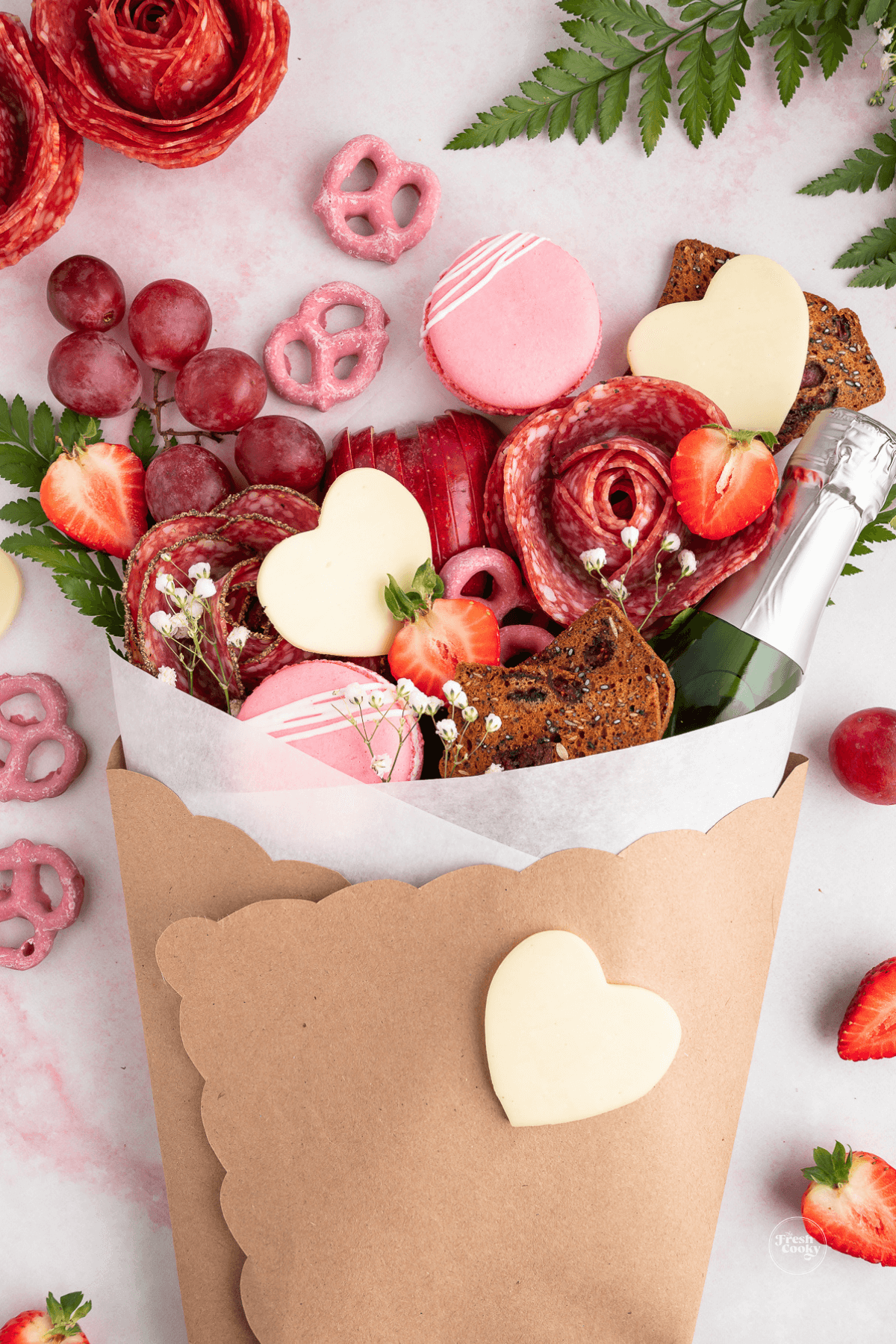 Charcuterie Bouquet with salami hearts, champagne, cookies and more all pink and red.