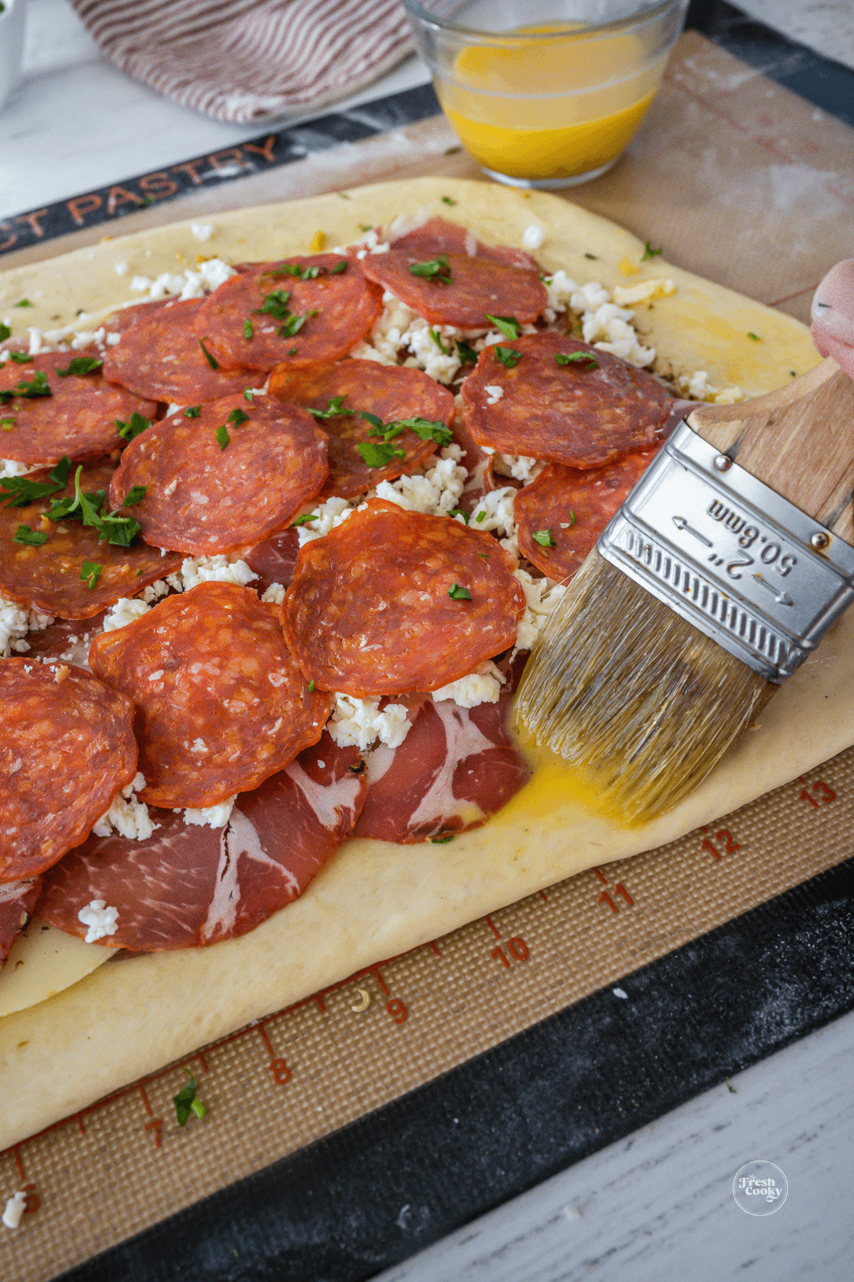 Brush around edges of dough before rolling stromboli to help it stick together.