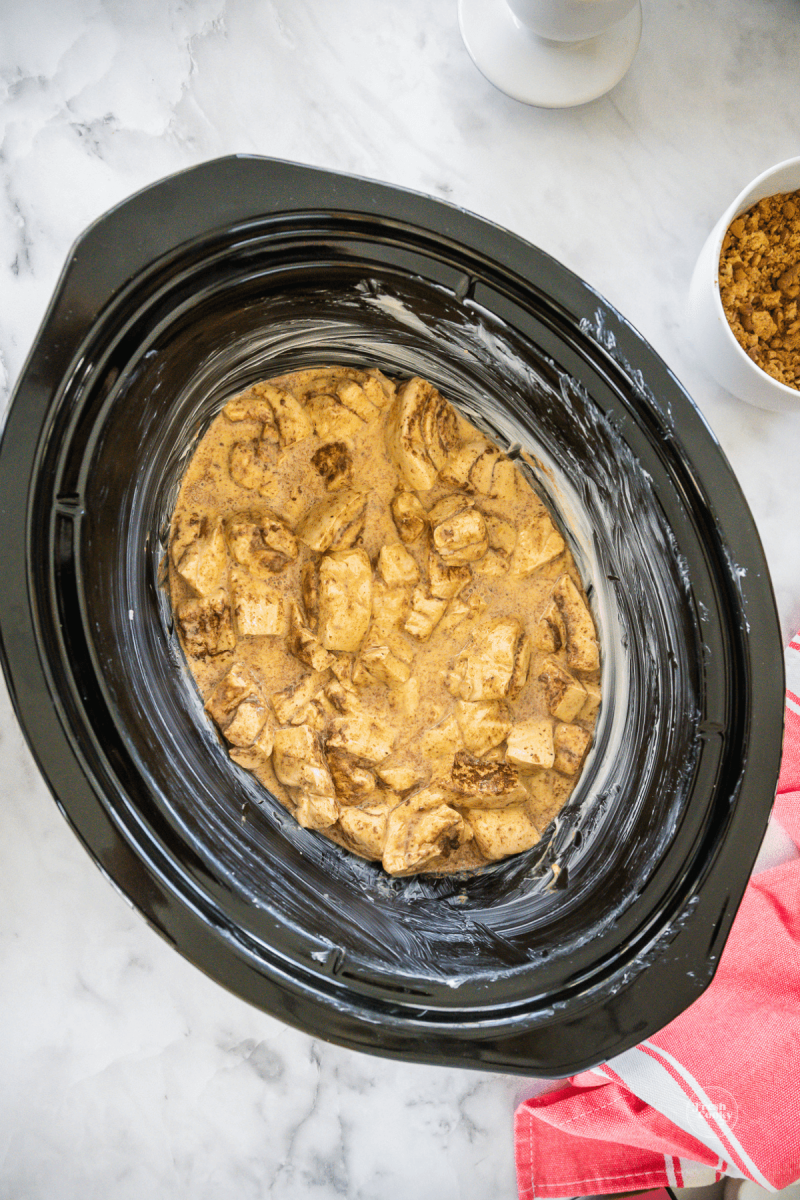 Cinnamon roll mixture poured into buttered crock pot. 