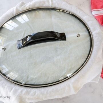 Tea towel placed between lid and cinnamon roll casserole to catch condensation.