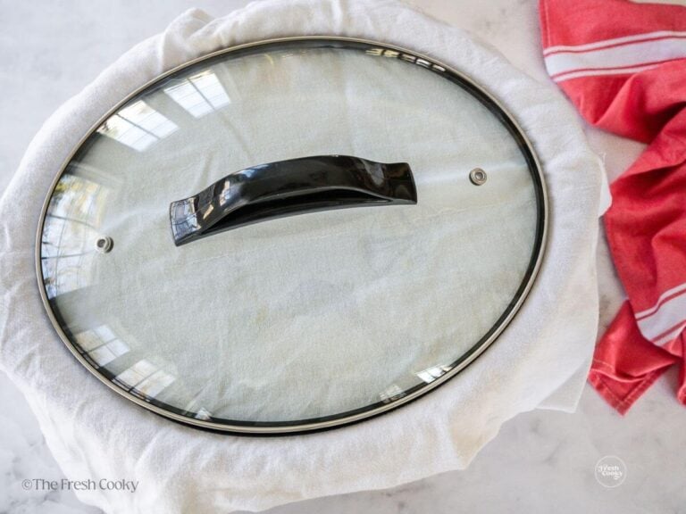 Tea towel placed between lid and cinnamon roll casserole to catch condensation.