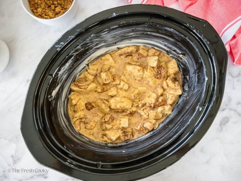 Cinnamon roll mixture poured into buttered crock pot.