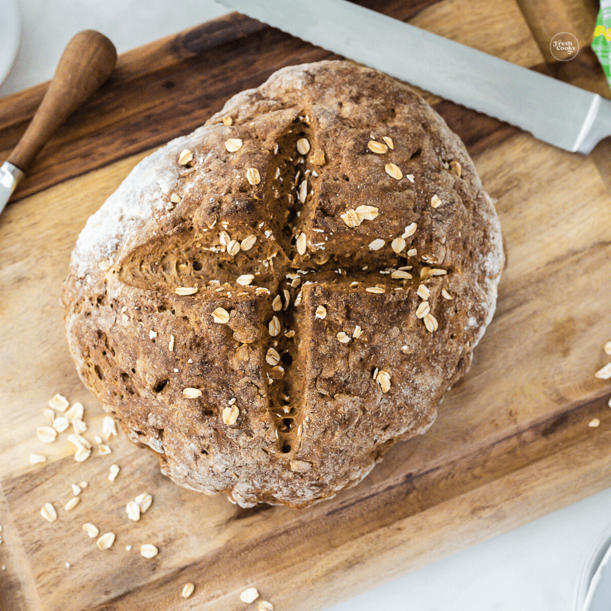 Irish brown bread on cutting board with serrated knife.