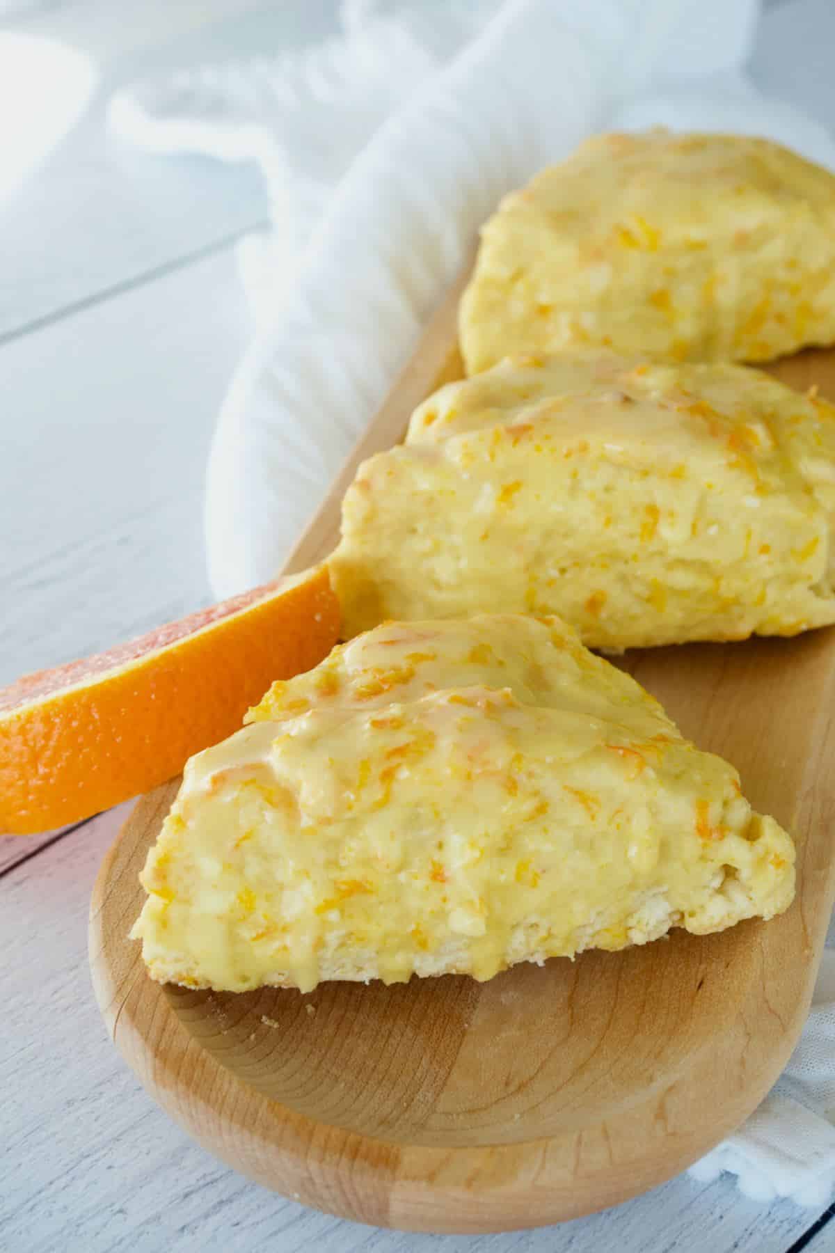 Panera bread orange scone recipe on wooden tray with three scones.