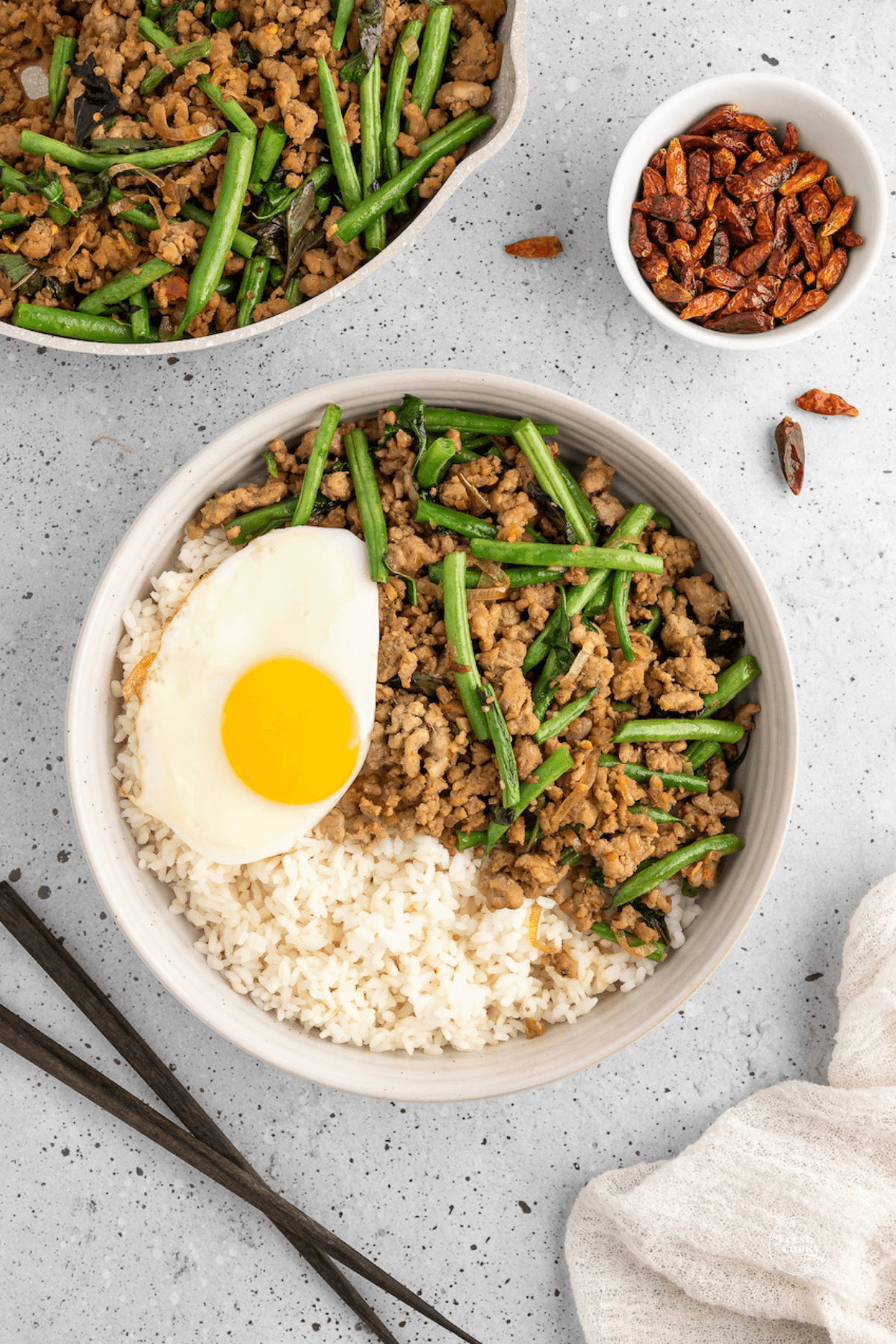 Pad Kra Pao, Thai Pork Stir-Fry in bowl with Bird's Eye Chiles, Thai fried egg and holy basil.