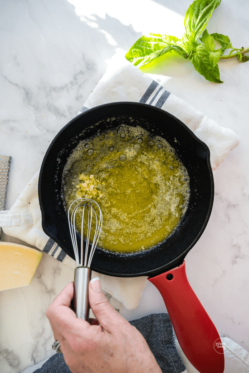 Sautéing garlic in butter for Alfredo sauce for Olive Garden stuffed shells recipe.