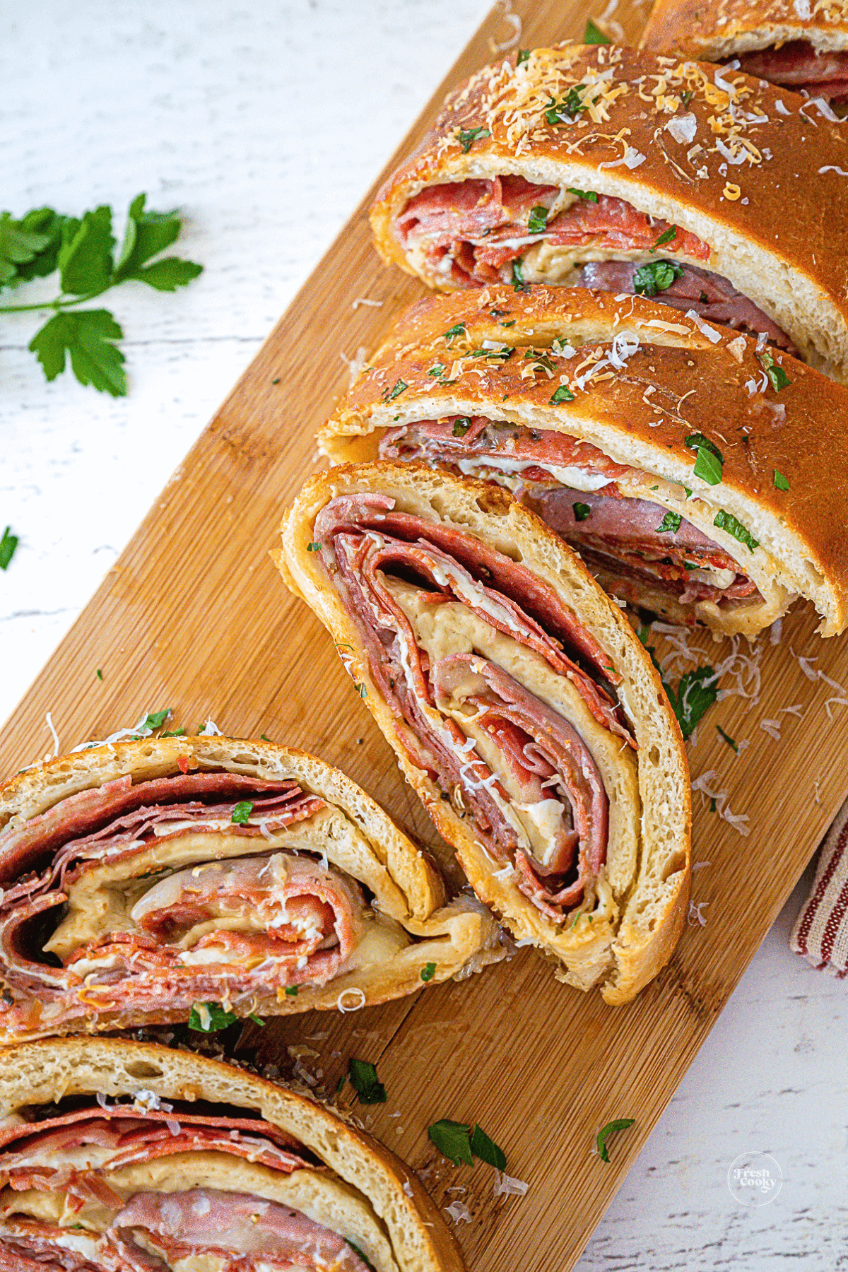 Italian stromboli slices on cutting board.