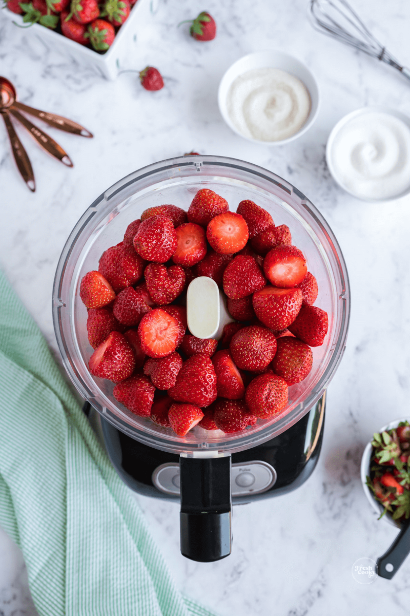 Whole, fresh strawberries in food processor for freezer jam.