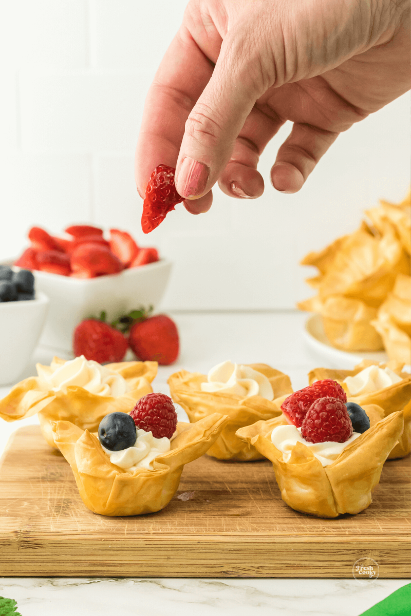 Add fresh berries to cheesecake cups with phyllo. 