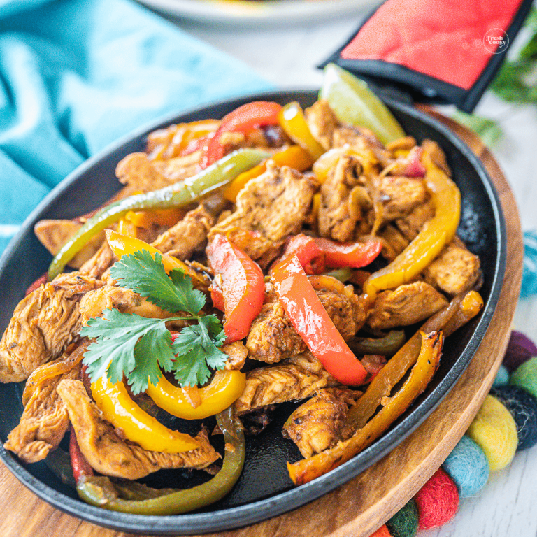 Delicious chicken fajitas in a cast iron pan.