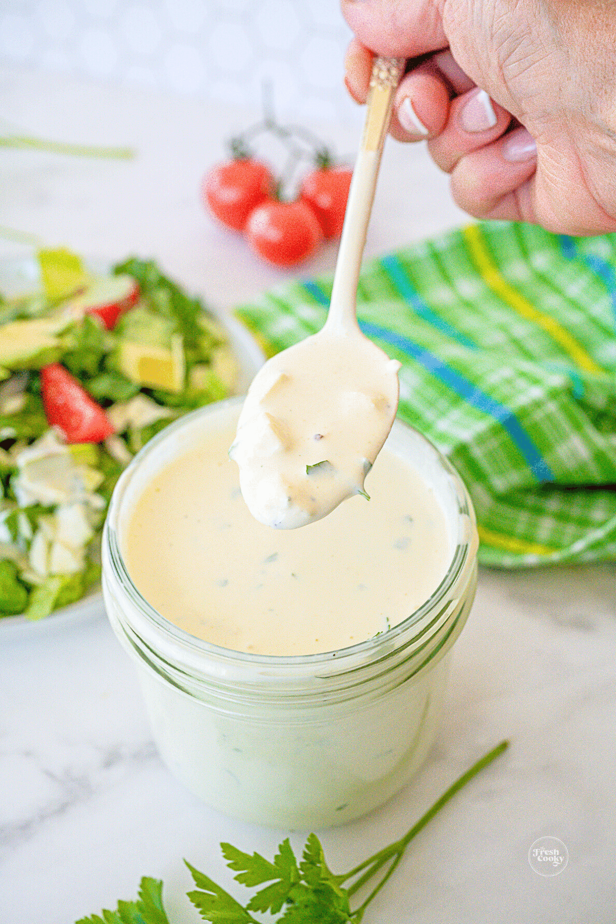 Homemade low carb blue cheese dressing recipe in jar with spoonful dripping to serve.