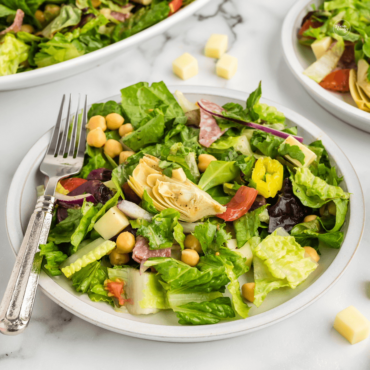 Italian chopped salad on plate with fork and dressed.