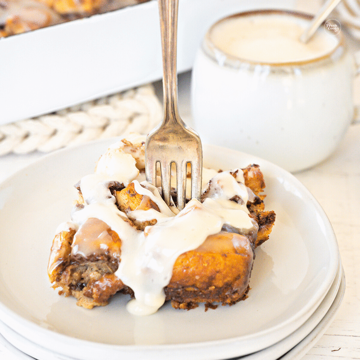 Cinnamon roll casserole with fork stuck in the middle of the slice.