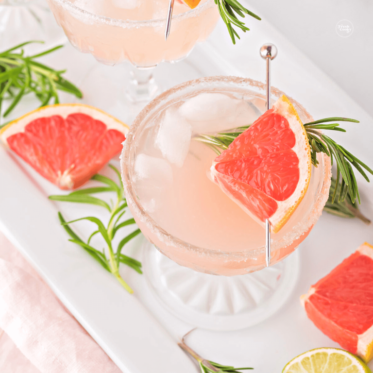 Skinny grapefruit paloma mocktail drink in pretty crystal couple glasses.