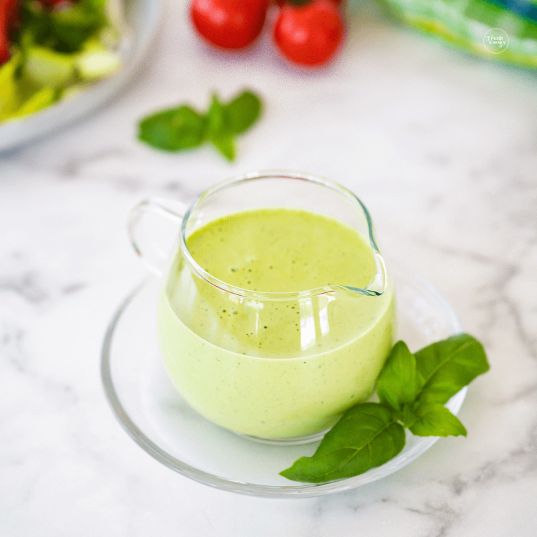 Green goddess salad dressing in pretty pitcher for serving.