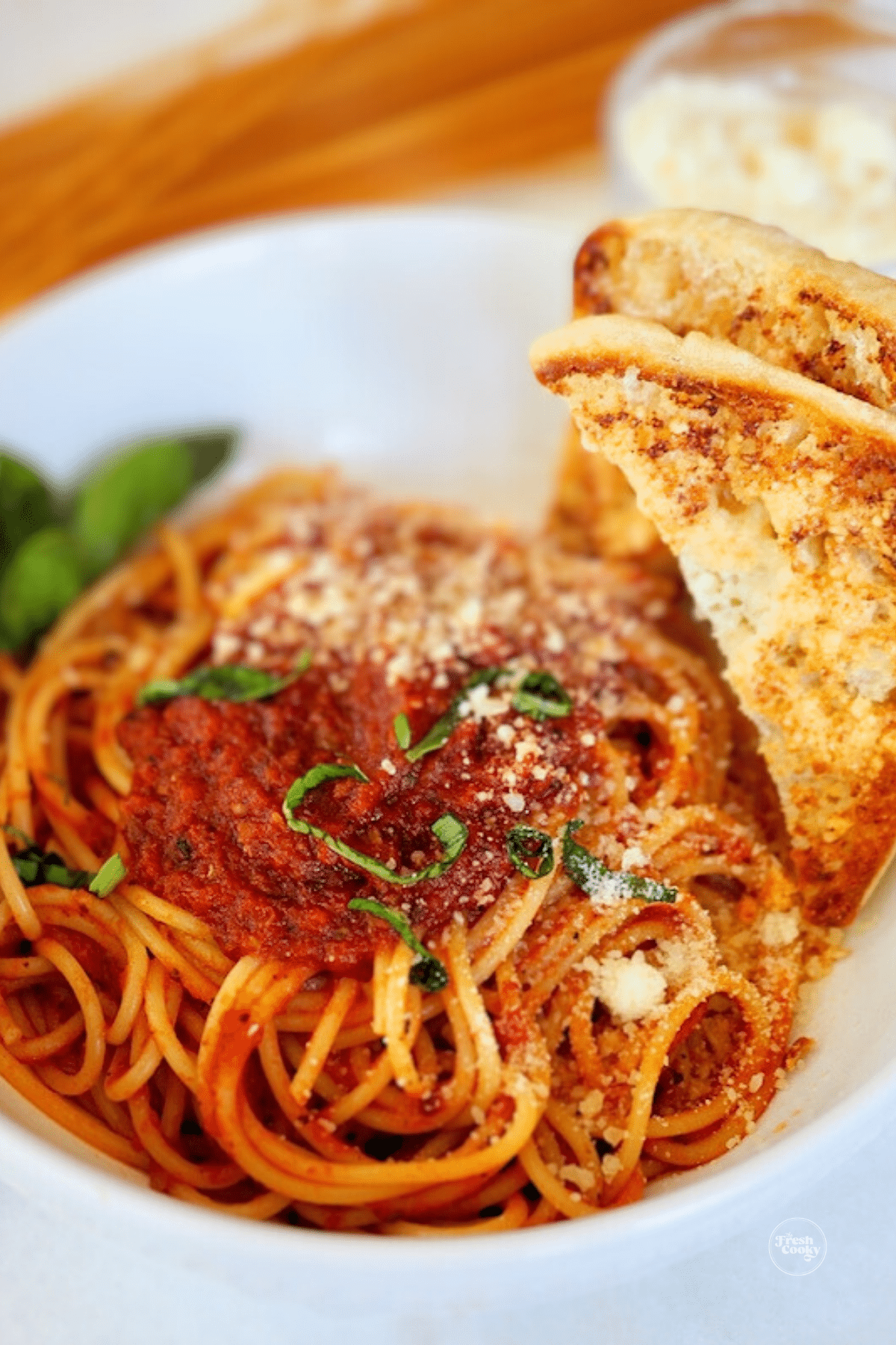 Pasta Sauce on mound of spaghetti with garlic bread.
