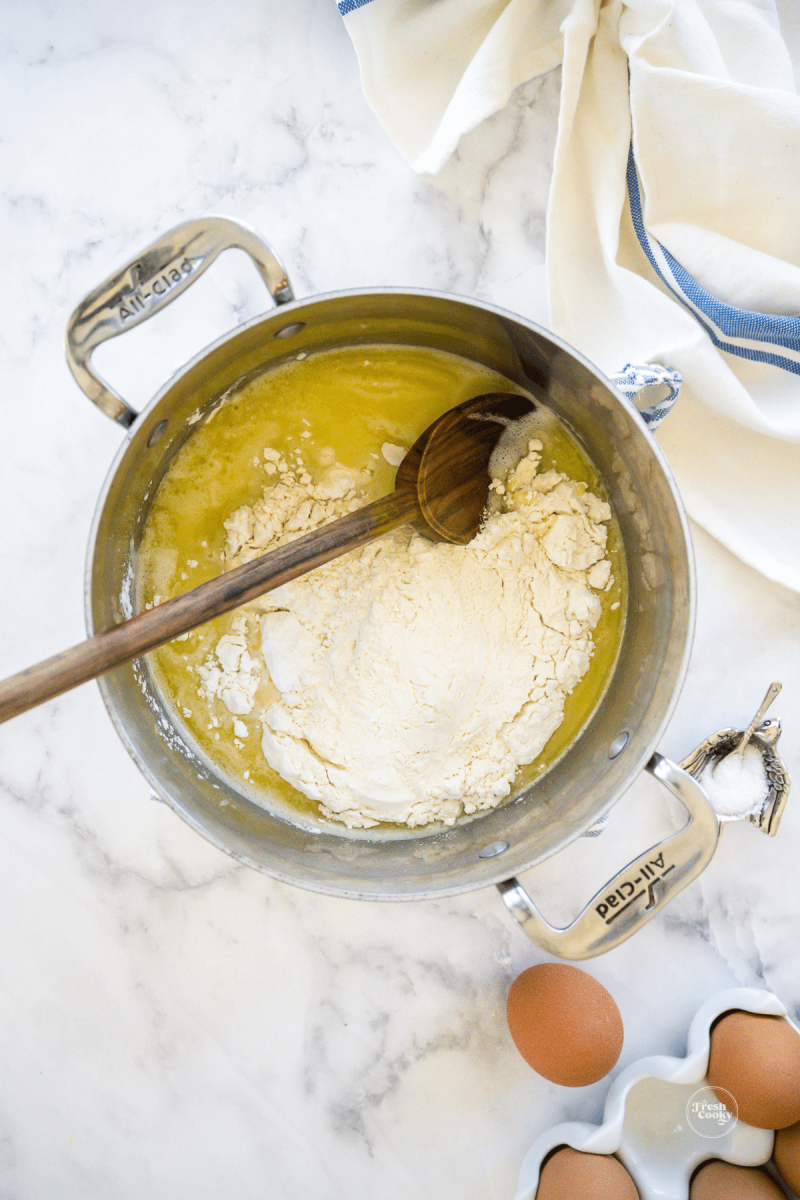 Adding all-purpose flour to butter and water. 