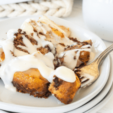 Grands cinnamon rolls recipe on plate with a fork holding a bite.