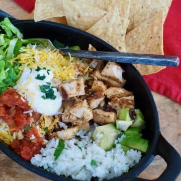 Copycat chipotle chicken bowl with chips, cilantro lime rice and toppings.