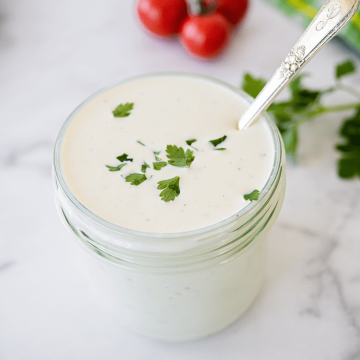 Blue cheese dressing in jar with pretty silver spoon.