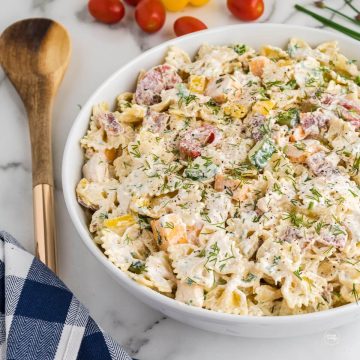 Chicken bacon ranch pasta salad in bowl with wooden spoon.