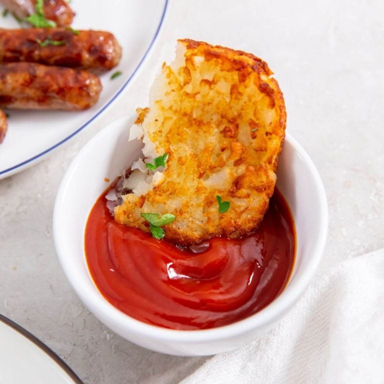 Air Fryer frozen hash brown patty dunked in ketchup.