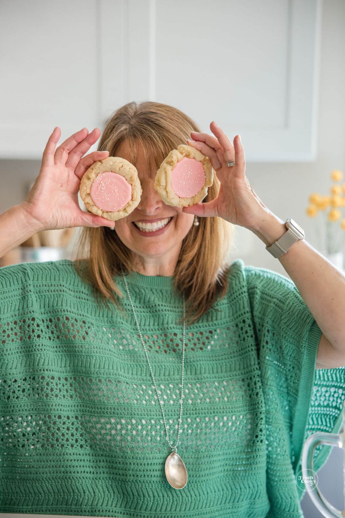 Kathleen, holding cookies in front of her eyes.